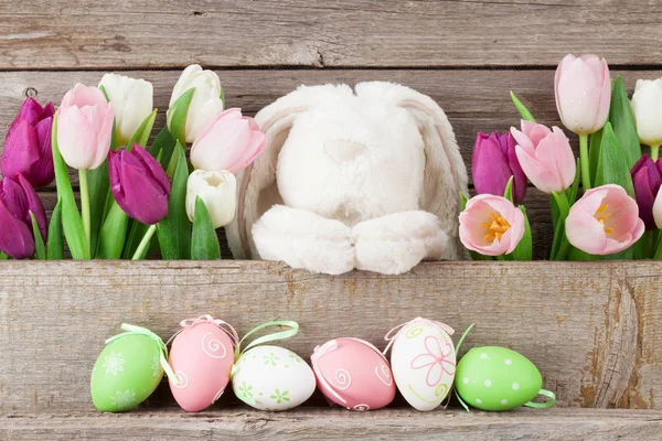 Easter eggs, rabbit toy and tulips — Stock Photo, Image