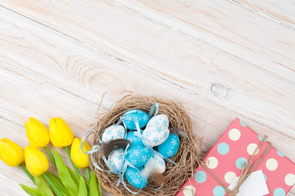 Eggs in nest, yellow tulips and coffee — Stock Photo, Image