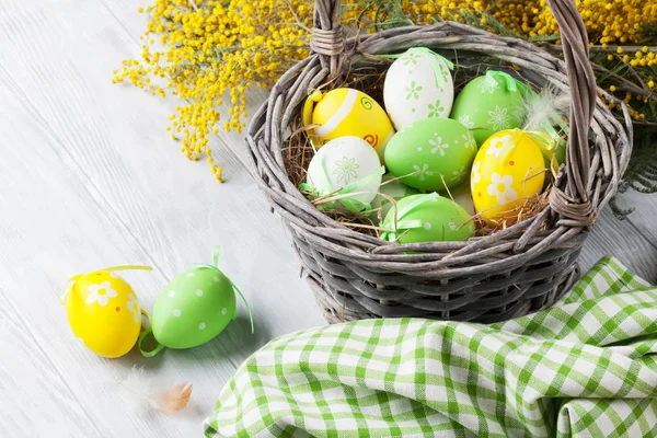 Paaseieren in de mand en mimosa — Stockfoto