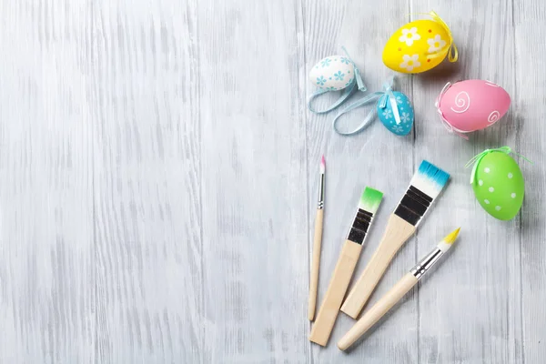 Colorful easter eggs and brushes — Stock Photo, Image