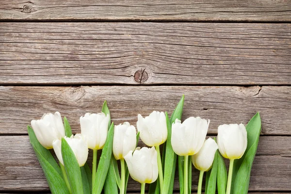 Białe tulipany na drewnianym tle — Zdjęcie stockowe