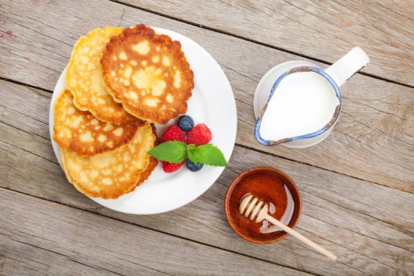 Pancakes with berries, milk and honey — Stock Photo, Image