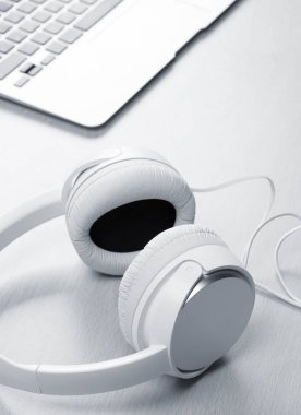 Masada kulaklık ve dizüstü bilgisayar var.