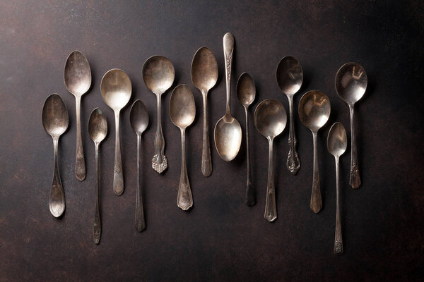 Старые винтажные ложки на каменном столе
