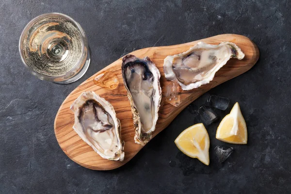 Ostras en tabla de cortar y vino blanco —  Fotos de Stock