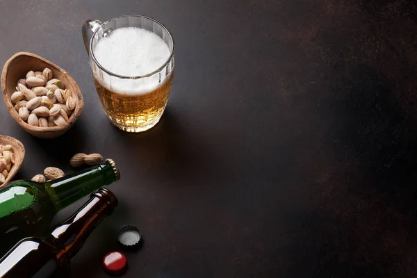 Taza de cerveza, nueces y botellas — Foto de Stock