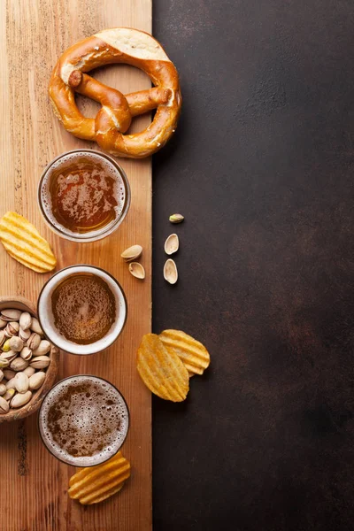 Canecas de cerveja, nozes, batatas fritas e pretzel — Fotografia de Stock