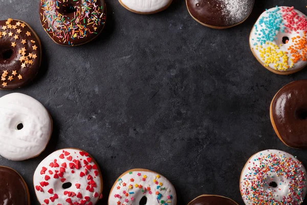 Donuts coloridos na mesa de pedra — Fotografia de Stock