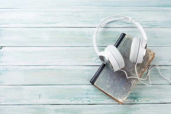 Headphones and old book — Stock Photo, Image