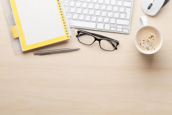 computer, coffee cup, eyeglasses and notepad
