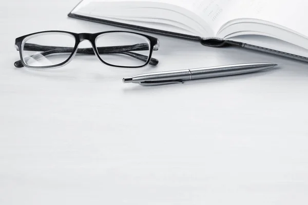 Блокнот, ручка и очки — стоковое фото