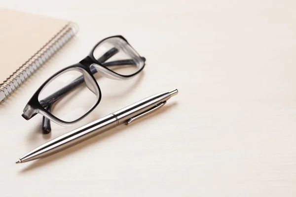 Notepad, pen and glasses Stock Photo