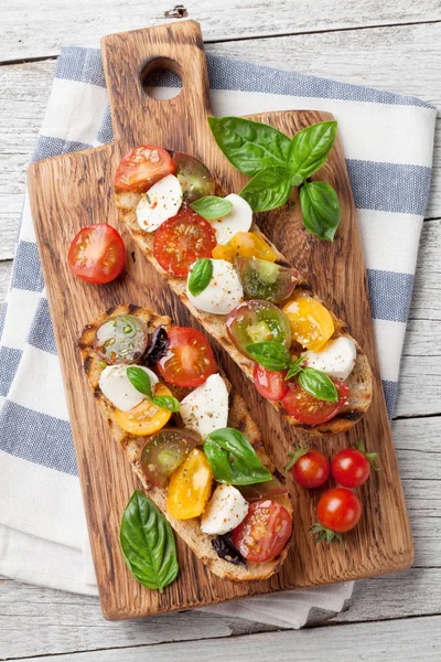 Bruschetta con tomates, mozzarella y albahaca —  Fotos de Stock