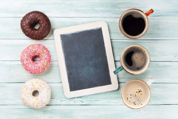 Copos de café e donuts coloridos — Fotografia de Stock