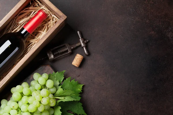 Garrafa de vinho em caixa e uvas — Fotografia de Stock