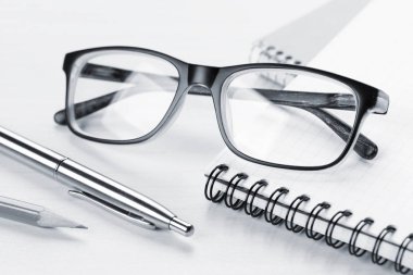 Bloknot, kalem, kurşun kalem ve gözlük 