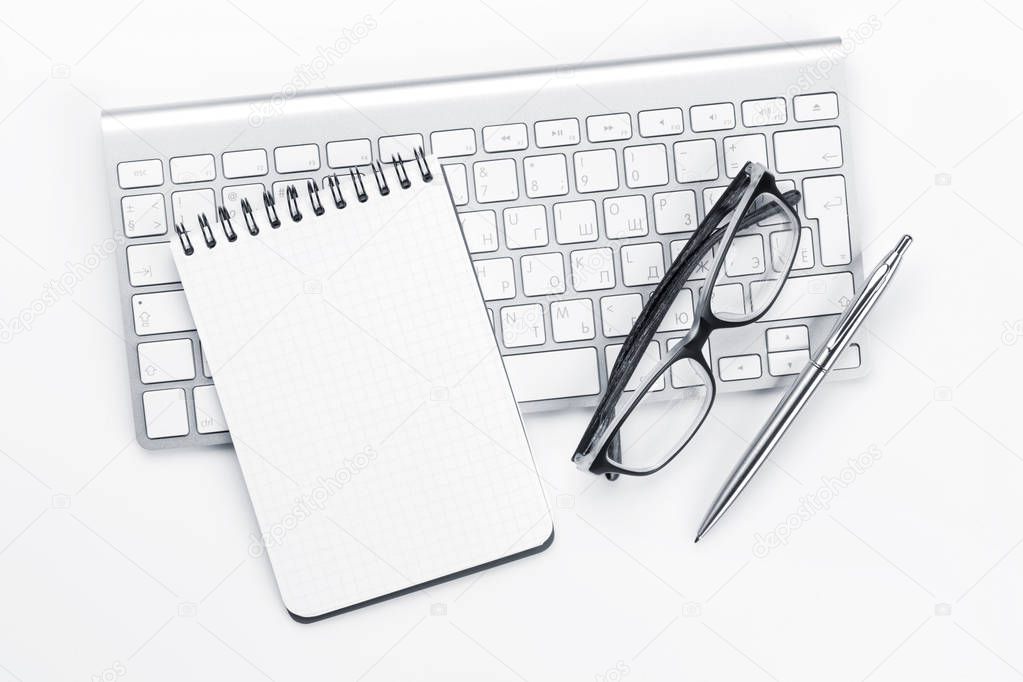 keyboard, notepad, eyeglasses and pen