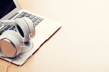 Masada kulaklık ve dizüstü bilgisayar var.