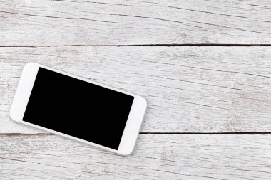 Ahşap masa üstünde beyaz smartphone