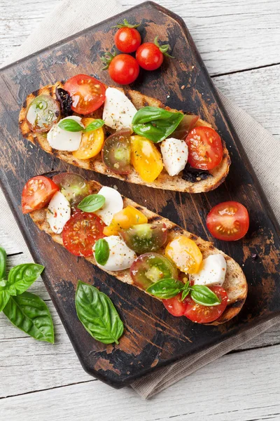 Bruschetta con tomates, mozzarella y albahaca —  Fotos de Stock