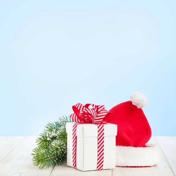 Vánoční dárková krabička, santa čepice a jedle strom — Stock fotografie