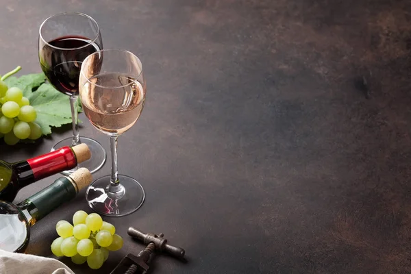 Винные бутылки, бокалы и виноград — стоковое фото