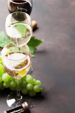 Şarap, gözlük ve taş masada Yeşil üzüm. Boşlukla