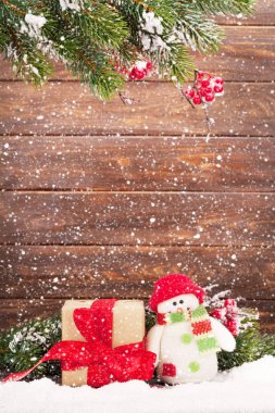 Noel tebrik kartı ile xmas ağacı ve kardan adam oyuncak ahşap duvar önünde. Boşlukla 