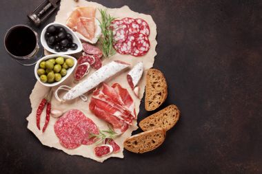 Salam, jambon, sosis, jambon, pastırma, zeytin, ekmek ve kırmızı şarap cam dilimlenmiş. Kopya alanı ile Üstten Görünüm