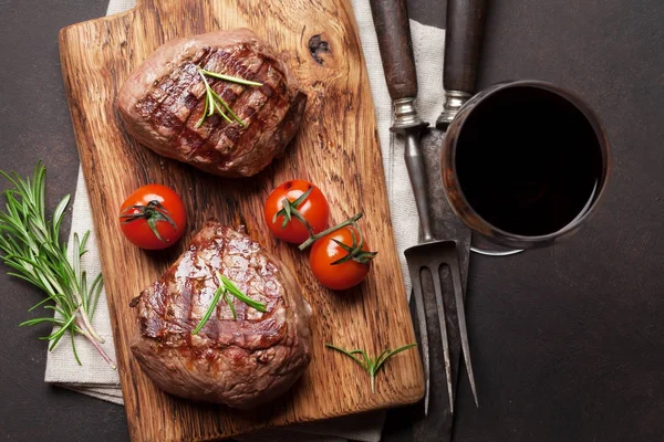 Gegrilde Steaks Een Snijplank Een Glas Rode Wijn Bovenaanzicht — Stockfoto