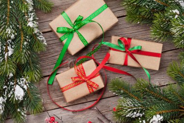 Noel hediye kutuları ve karlı köknar ağacı ahşap masa üzerinde. Üstten Görünüm