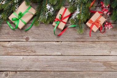 Noel hediye kutuları ve karlı köknar ağacı ahşap masa üzerinde. Üstten Görünüm alanı ile