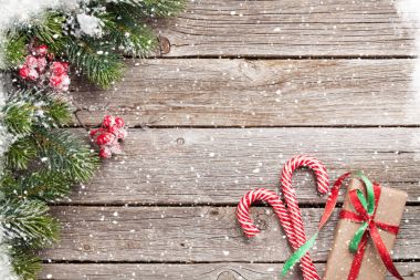 Noel hediye kutusu, şekerler ve karlı köknar ağacı ahşap masa üzerinde. Üstten Görünüm alanı ile