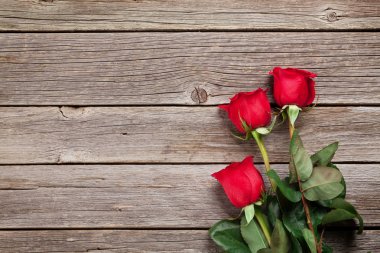 Sevgililer günü tebrik kartı. Kırmızı gül ahşap masa üzerinde. Üstten Görünüm alanı ile