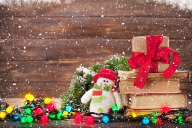 Noel tebrik kartı xmas ağacı, kitap, hediye kutusu, ışıklar ve kardan adam oyuncak 