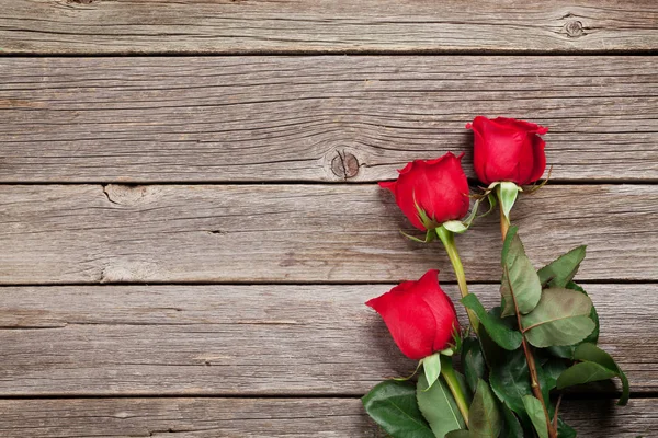 Sevgililer günü tebrik kartı. Kırmızı gül ahşap masa üzerinde. Üstten Görünüm alanı ile
