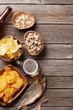 Lager bira bardağı ve ahşap masa snacks. Kuruyemiş, cips ve kuru balık. Kopya alanı ile Üstten Görünüm