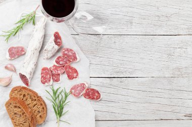 Salam, ekmek ve kırmızı şarap cam. Ahşap masa üzerinde et meze tabağı. Kopya alanı ile Üstten Görünüm