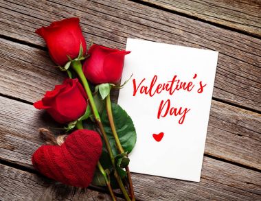 Sevgililer günü tebrik kartı, kırmızı gül ve kalp ahşap masa üzerinde. Kopya alanı ile Üstten Görünüm