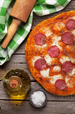 Ahşap masa üstünde pepperoni pizza. Üstten Görünüm