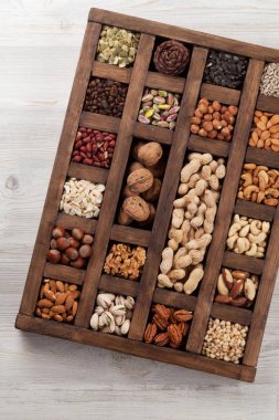 Çeşitli fındık seçim: fıstık, fındık, kestane, ceviz, Antep fıstığı ve pecans ahşap kutusunda. Üstten Görünüm