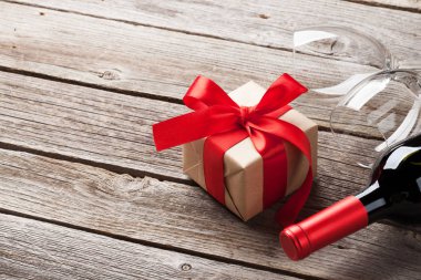 Sevgililer günü tebrik kartı. Kırmızı şarap ve Hediyelik kutu ahşap masa. Kopya alanı ile 