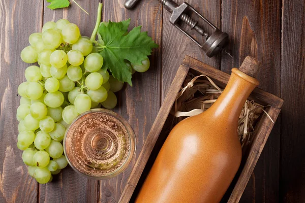 酒瓶和葡萄在木桌上 顶部视图 — 图库照片