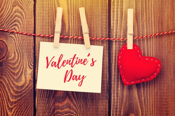 Fotoğraf çerçevesi ve el yapımı Sevgililer günü kalp ahşap arka plan üzerinde