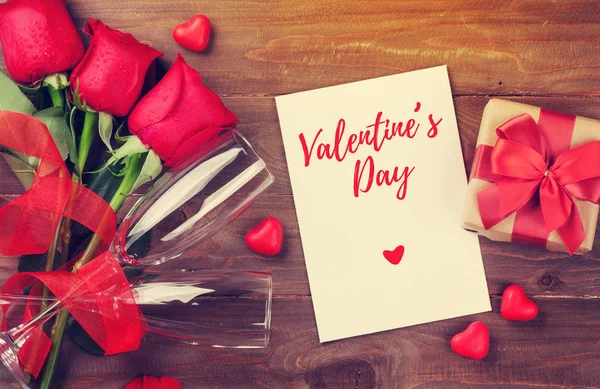 バレンタインの日のグリーティング カード ギフト ボックス 木製のテーブルに赤いバラ コピー スペース平面図 — ストック写真