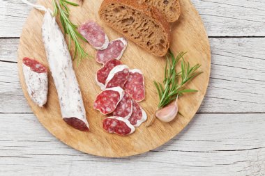 Dilimlenmiş salam ve ekmek. Ahşap masa üzerinde et meze. Üstten Görünüm