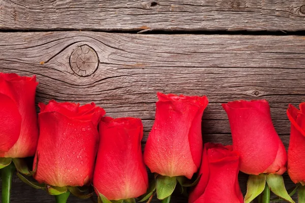 情人节贺卡与红玫瑰在木桌上 带空间的顶部视图 — 图库照片