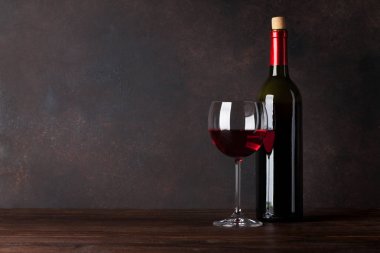 Kırmızı şarap şişe ve cam önünde tahta duvar. Kopya alanı ile metin için