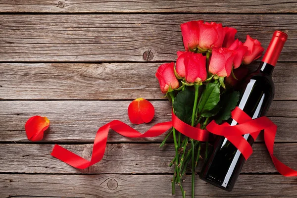 情人节贺卡上有红酒和玫瑰在木桌上 带空格的顶部视图 — 图库照片
