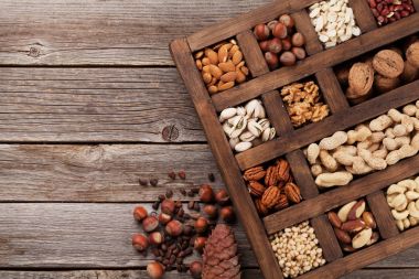 Çeşitli fındık seçim: fıstık, fındık, kestane, ceviz, Antep fıstığı ve pecans ahşap kutusunda. Üstten Görünüm alanı ile 